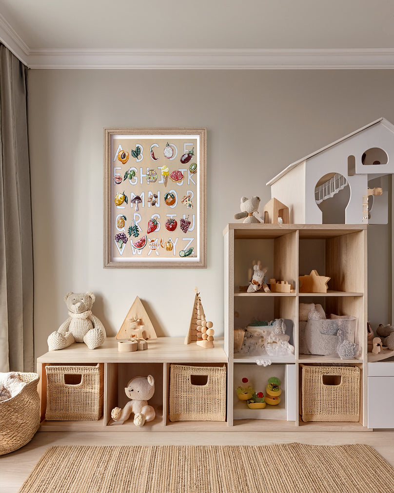 Alfabeto fine art print by marissa lico. Children's playroom with wooden shelves, toys, and a framed alphabet painting on the wall.