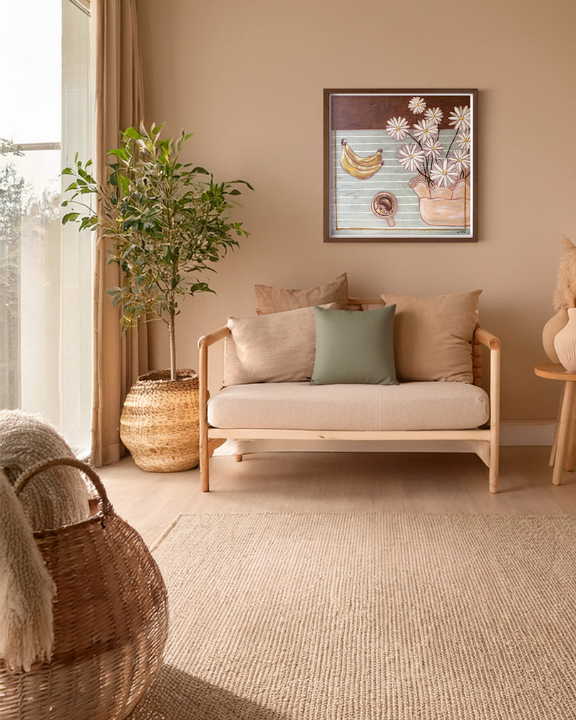 Breakfast with Margherita's fine art print by Marissa Lico. Living room with a beige sofa, decorative pillows, framed Marissa Lico print and a plant.