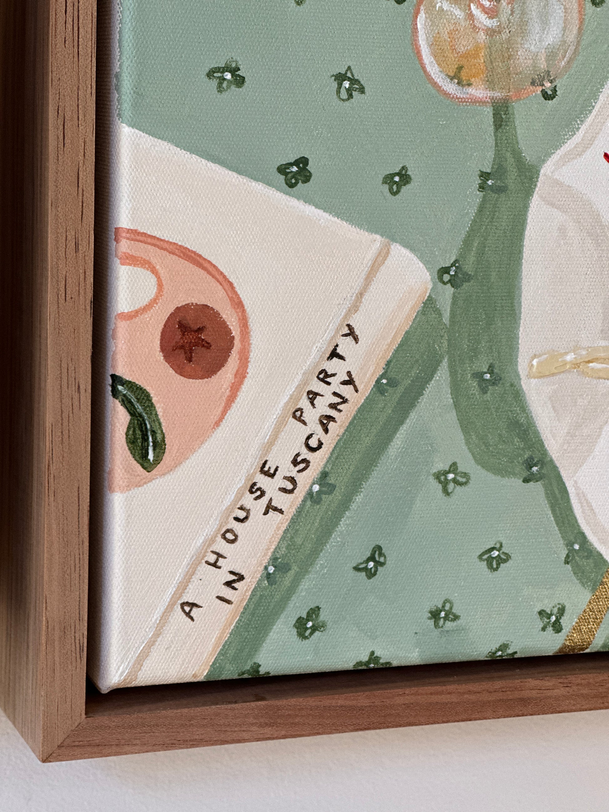 Domenica original painting by Marissa Lico. Framed artwork with a green and beige design, tablescape with a book and text on a white background.