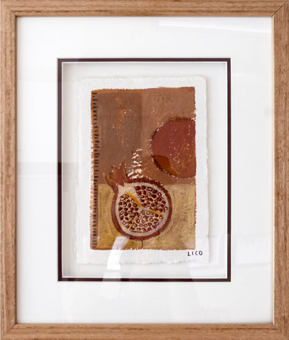 A framed abstract still life artwork featuring a pomegranate and warm earthy tones, presented in a light oak wood frame with a white mat.