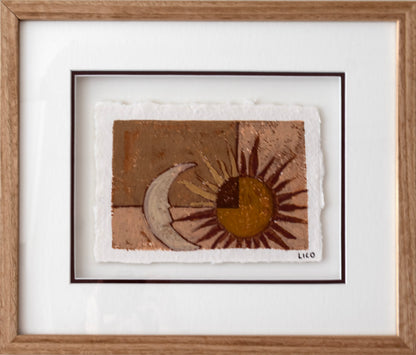 A framed handmade painting featuring a textured sun and crescent moon design in earthy brown, gold, and beige tones, presented in a light oak frame with a triple mat.