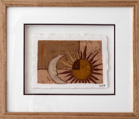 A framed handmade painting featuring a textured sun and crescent moon design in earthy brown, gold, and beige tones, presented in a light oak frame with a triple mat.