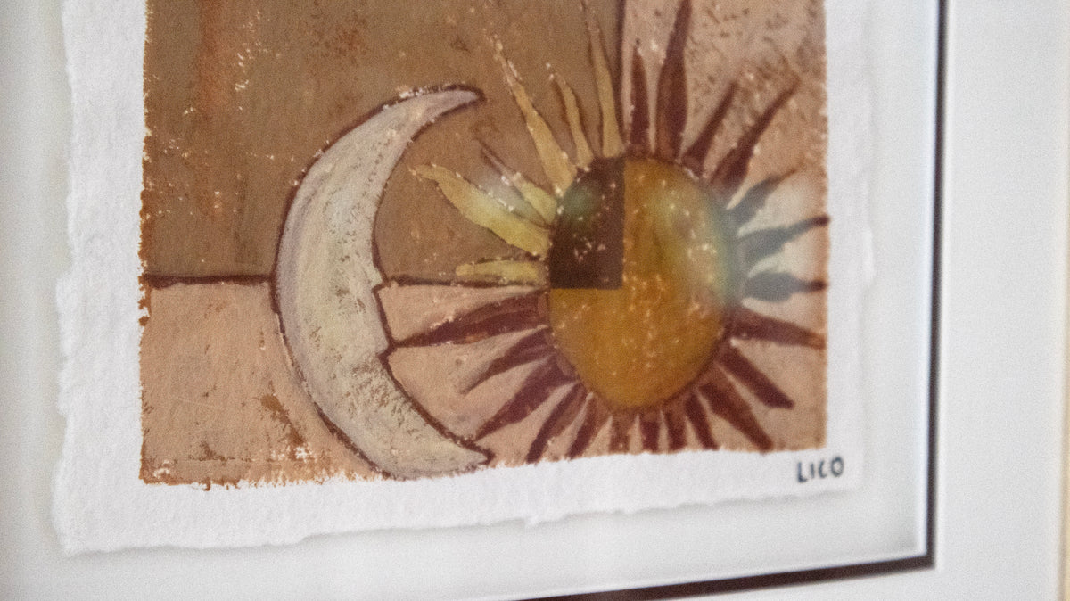 A close-up of a framed art painting featuring a textured painting of a crescent moon and a sun in earthy brown, beige, and ochre tones, with a white mat frame and artist signature  'LICO' in the bottom right.