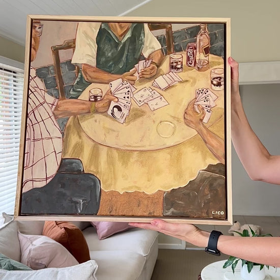 Video panning across an original acrylic painting of a family playing cards around a Sunday table, showing the textured brushwork up close.